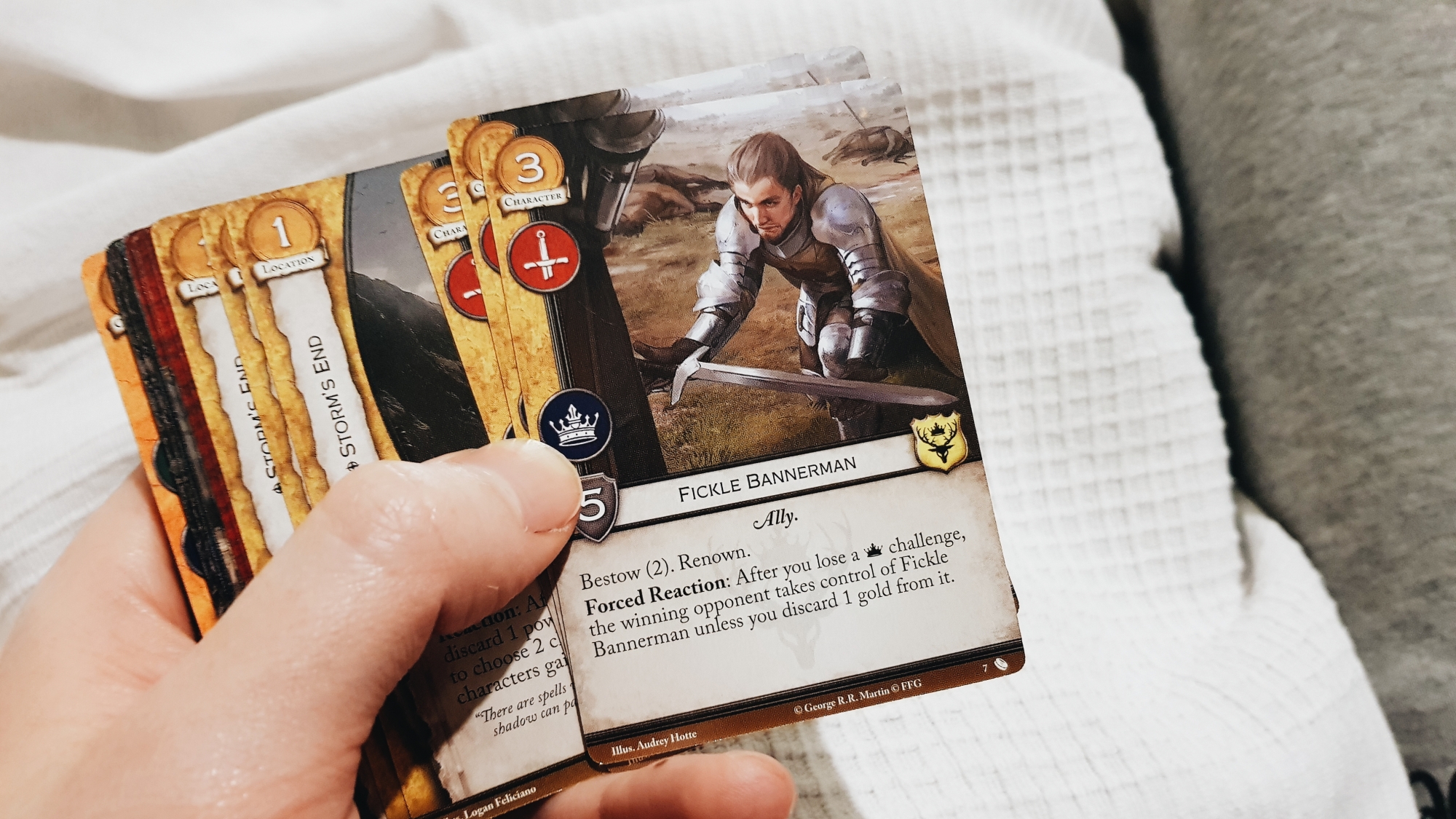A photo of a hand holding a set of Game of Thrones cards from the second edition game