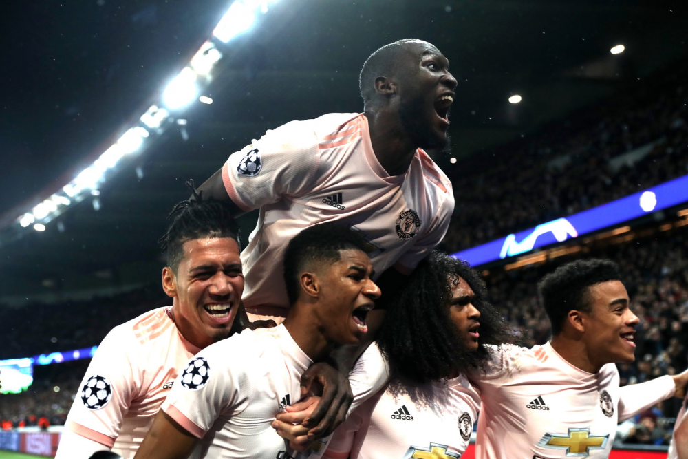 Several Manchester United players celebrate on the pitch after victory over PSG in the Champions League