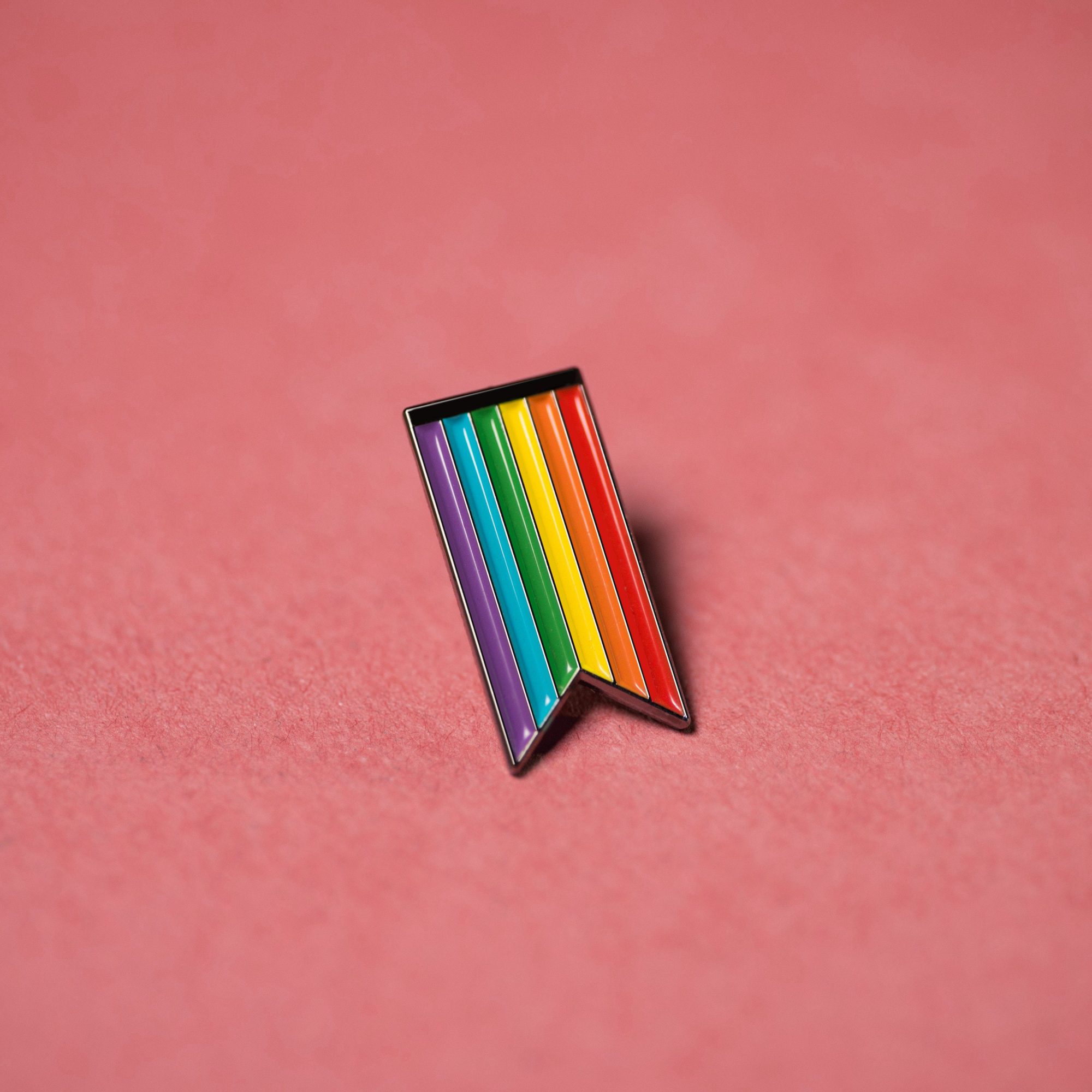 A close up photo of a rainbow flag pin badge