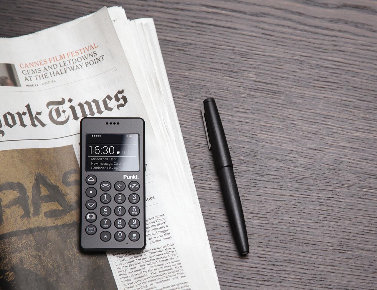 A 3D rendering of the Punkt. MP01 mobile phone on a copy of the New York Times newspaper, sat alongside a pen.