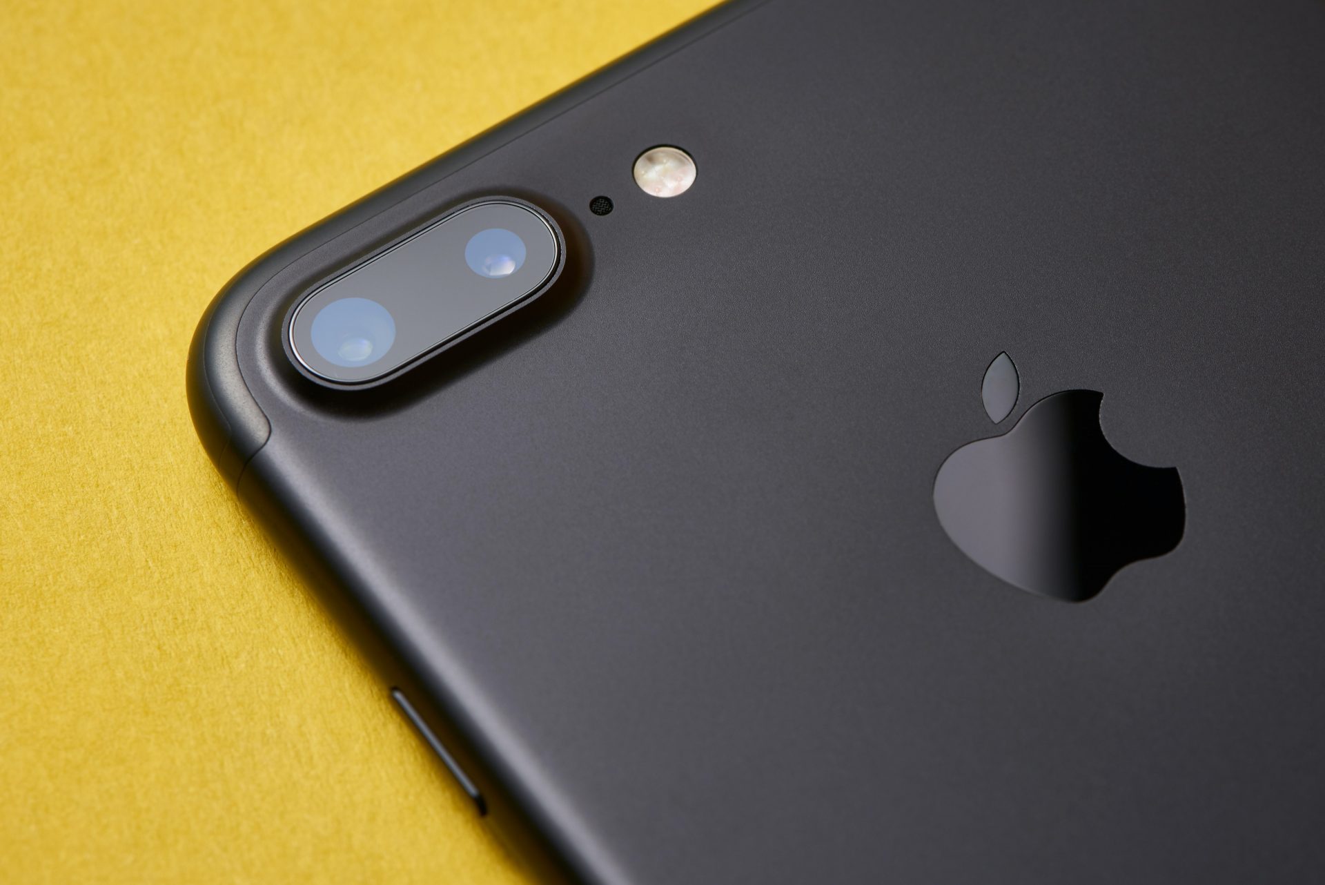 A photo of an iPhone on a yellow background