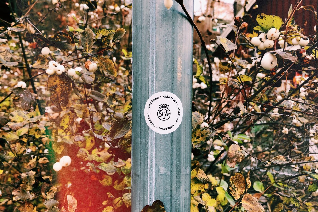 A photo of a sticker stuck to a lamppost. The sticker advertised oslo.town