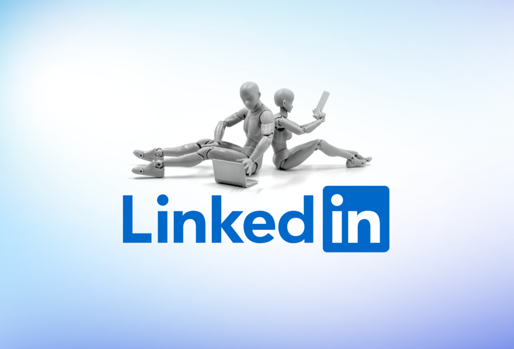 A logo for LinkedIn, but sat above the logo are two plastic figures representing AI-robots and they each use a digital device. One a laptop and the other a phone.